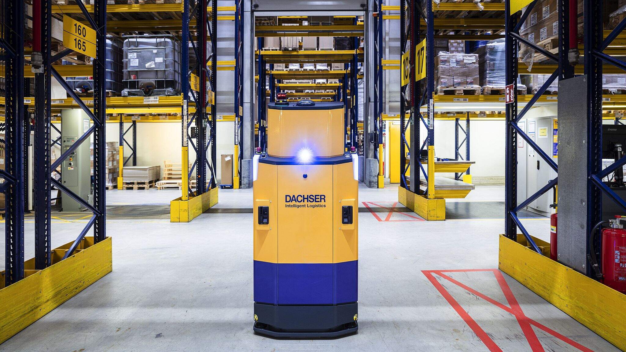 Een autonoom voertuig (AGV) navigeert zelfstandig door een DACHSER-warehouse.
 